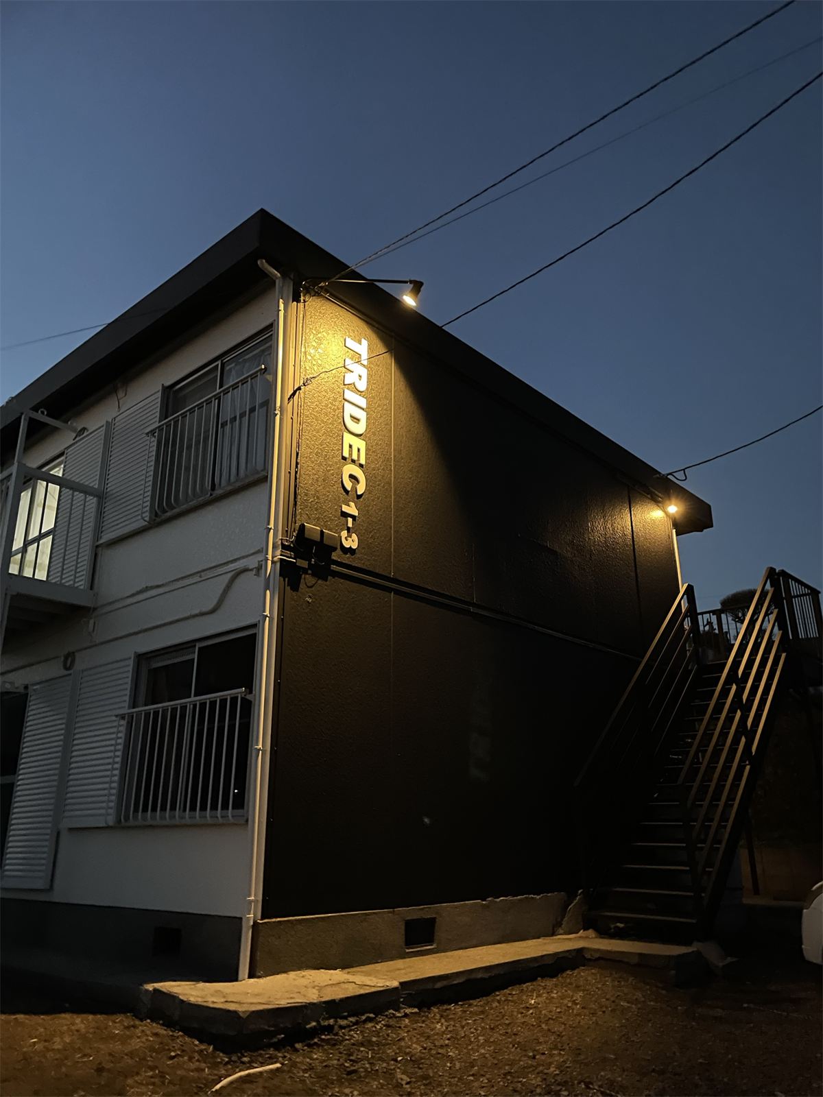 TRIDEC 1〜3号棟(鹿屋市 西原)の夜の外観。照明に照らされた「TRIDEC 1-3」の文字